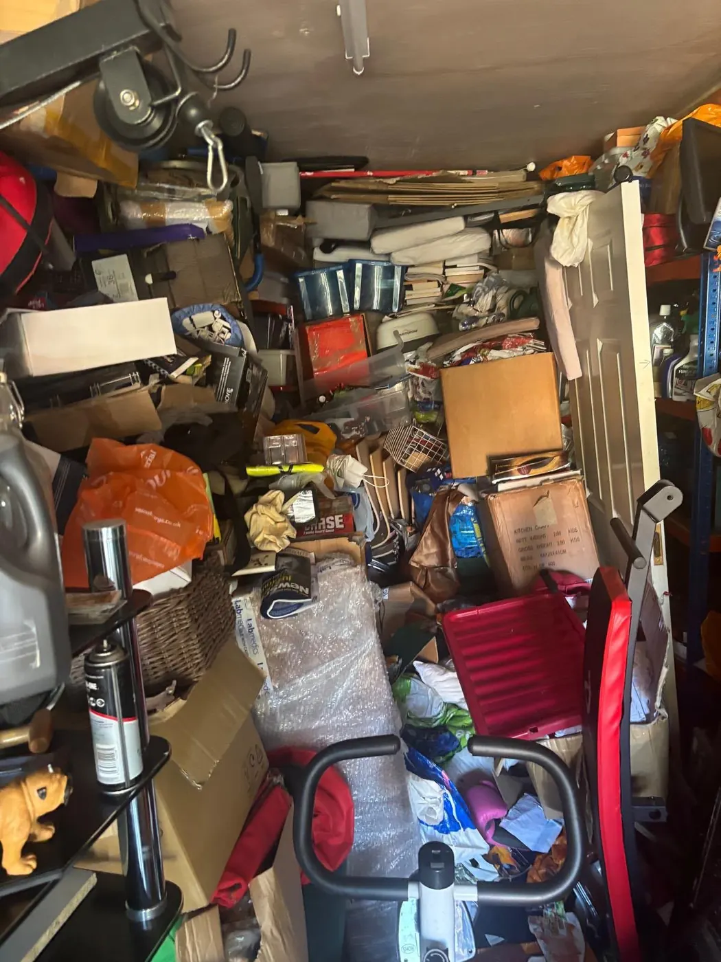 Packed storage area with boxes, bags, furniture and exercise equipment for clearance