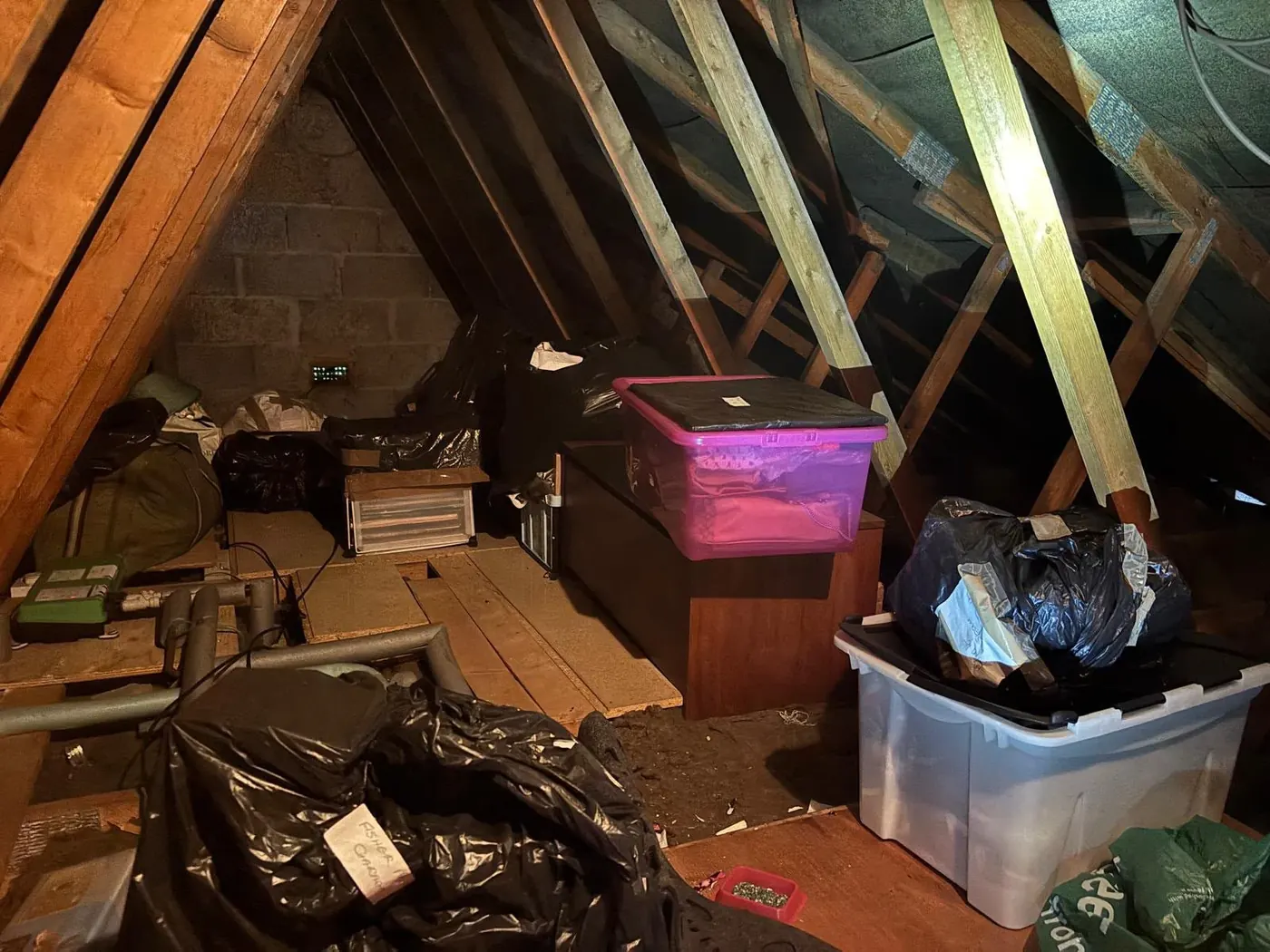 Loft clearance with bags, storage boxes and timber stored between roof rafters