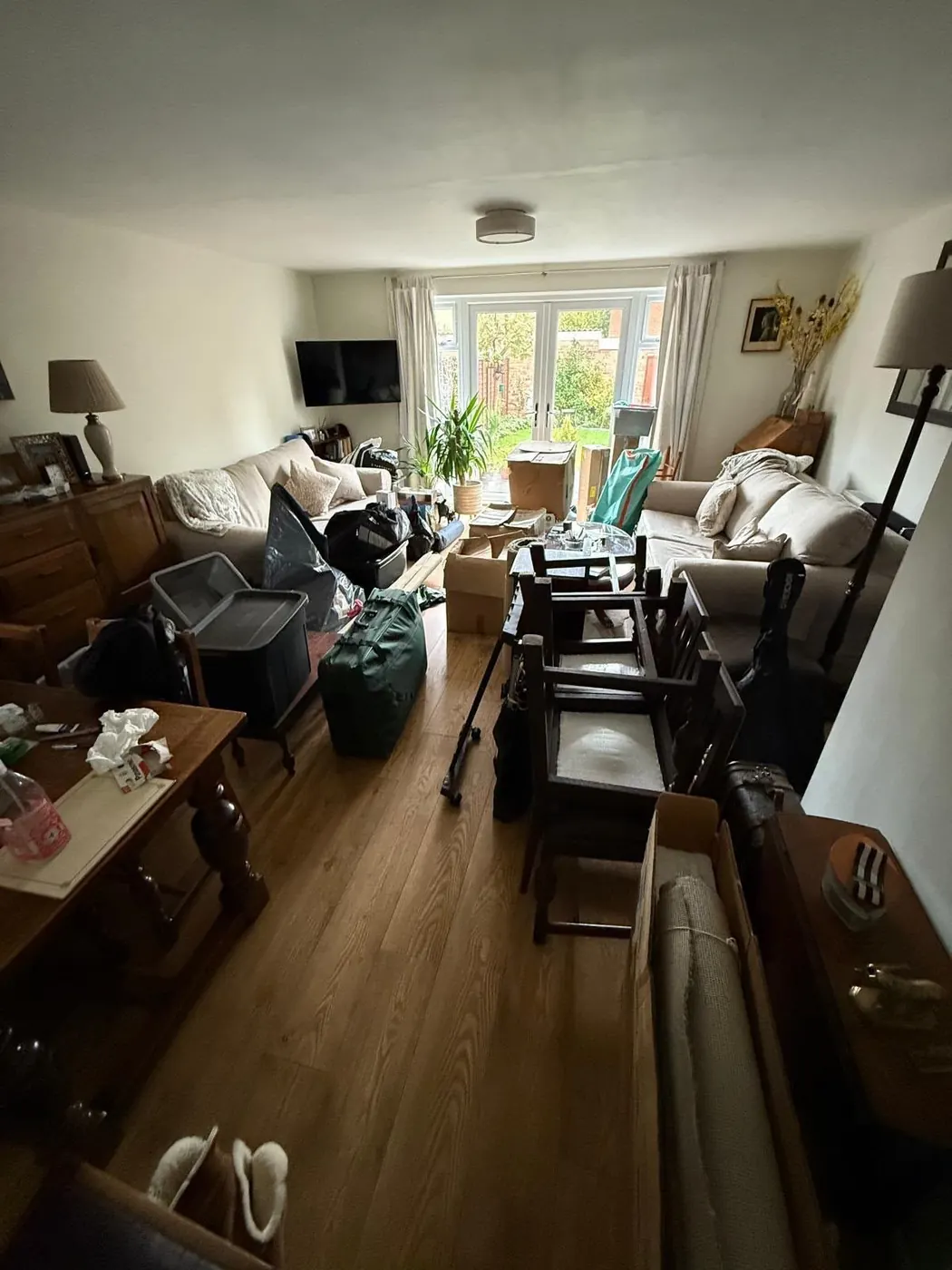Cluttered living room with furniture and boxes before a full property clearance in Oxfordshire