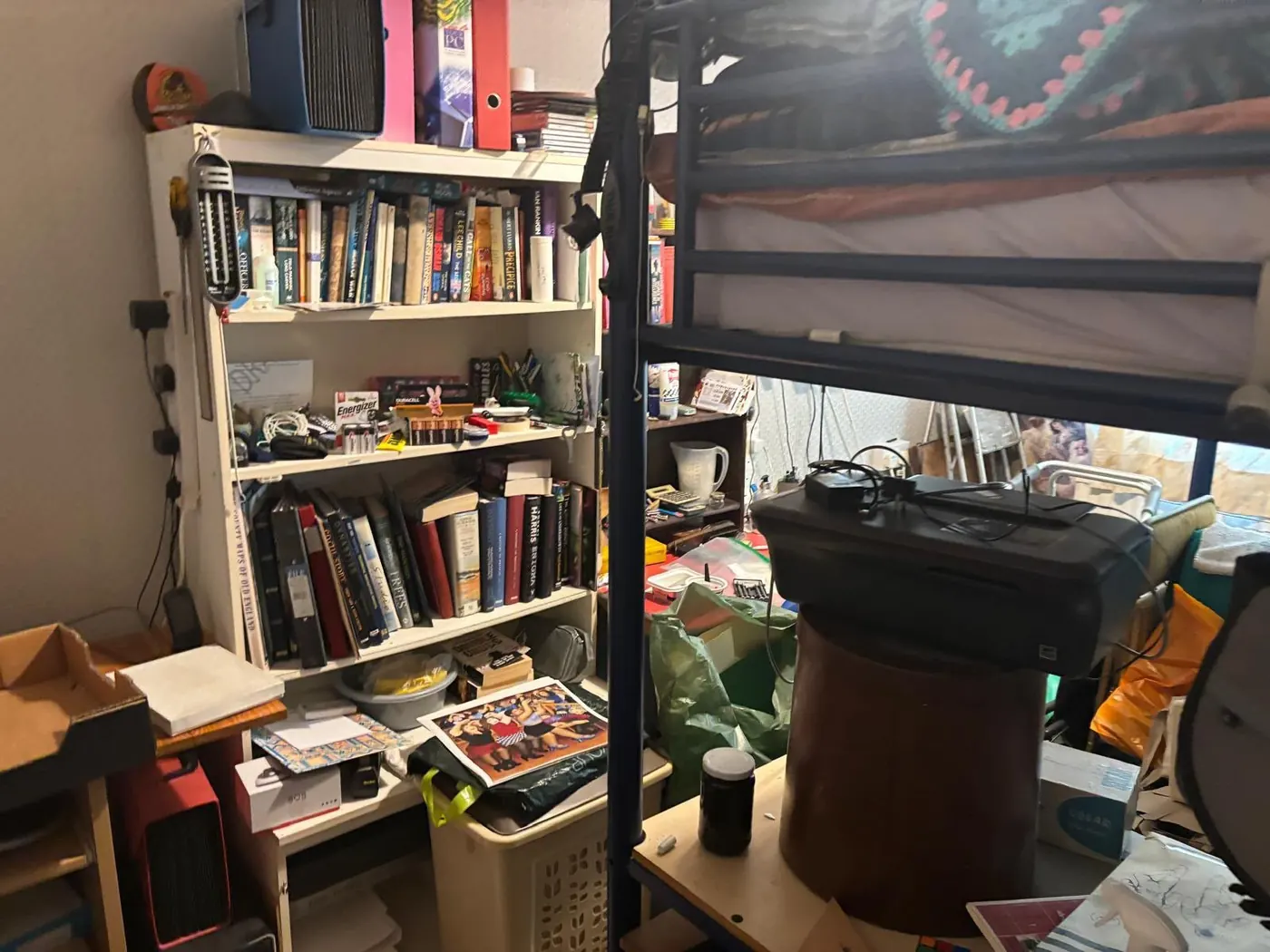 Crowded bedroom with bunk bed, shelving and stored possessions awaiting clutter clearance