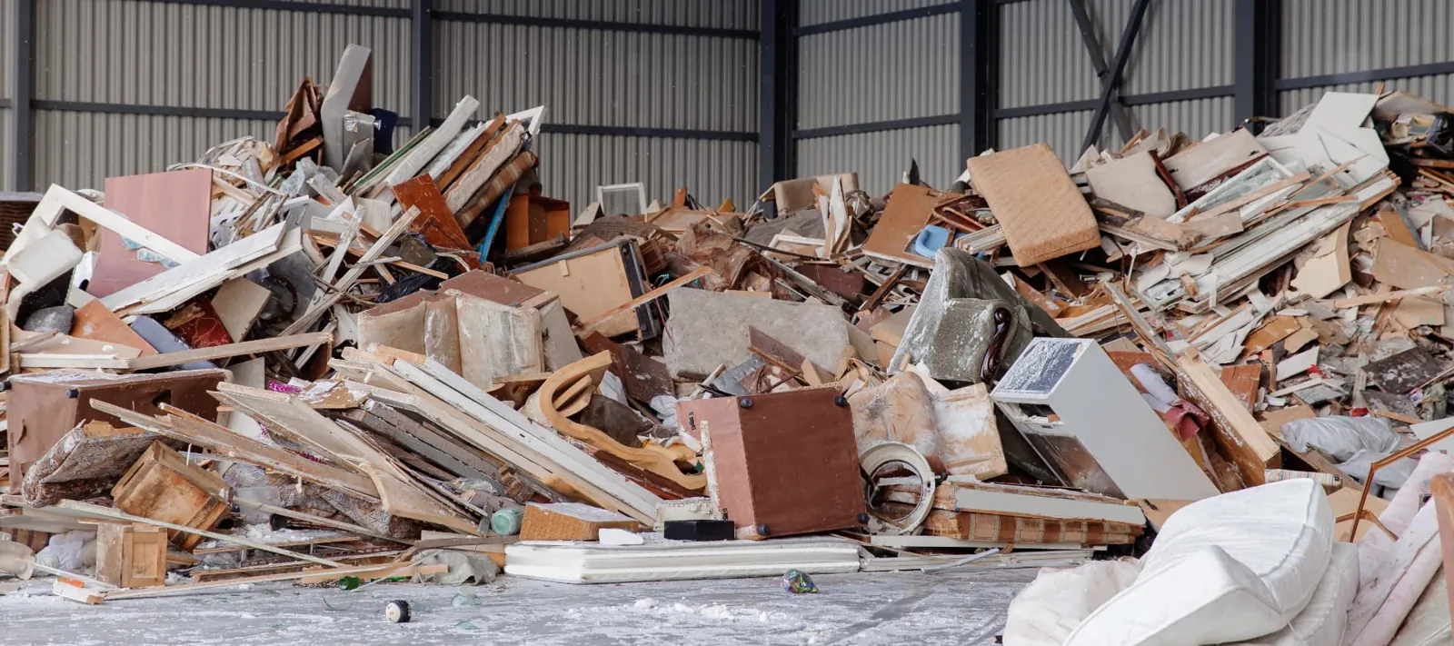 Cleared furniture, timber and mattresses sorted in a waste transfer bay for reuse and recycling