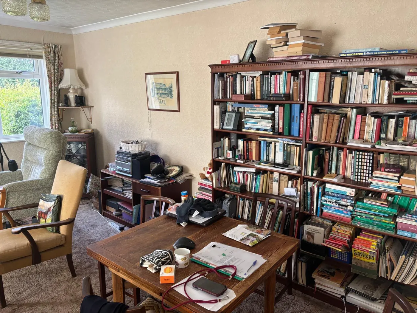 Wall of overfilled bookshelves cleared during a hoarding clearance in Oxfordshire