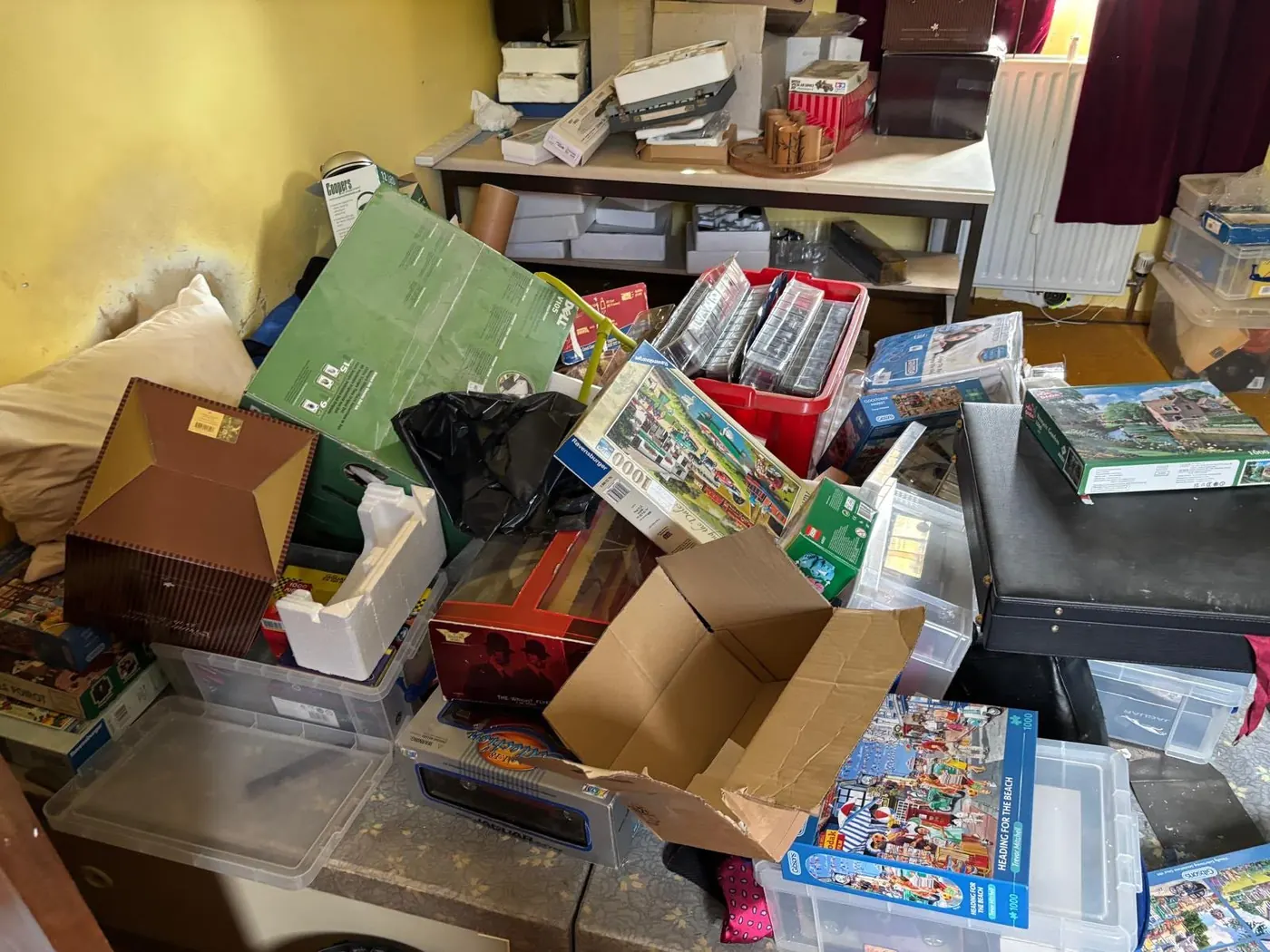 Stacked boxes, games and storage containers cleared during a clutter clearance