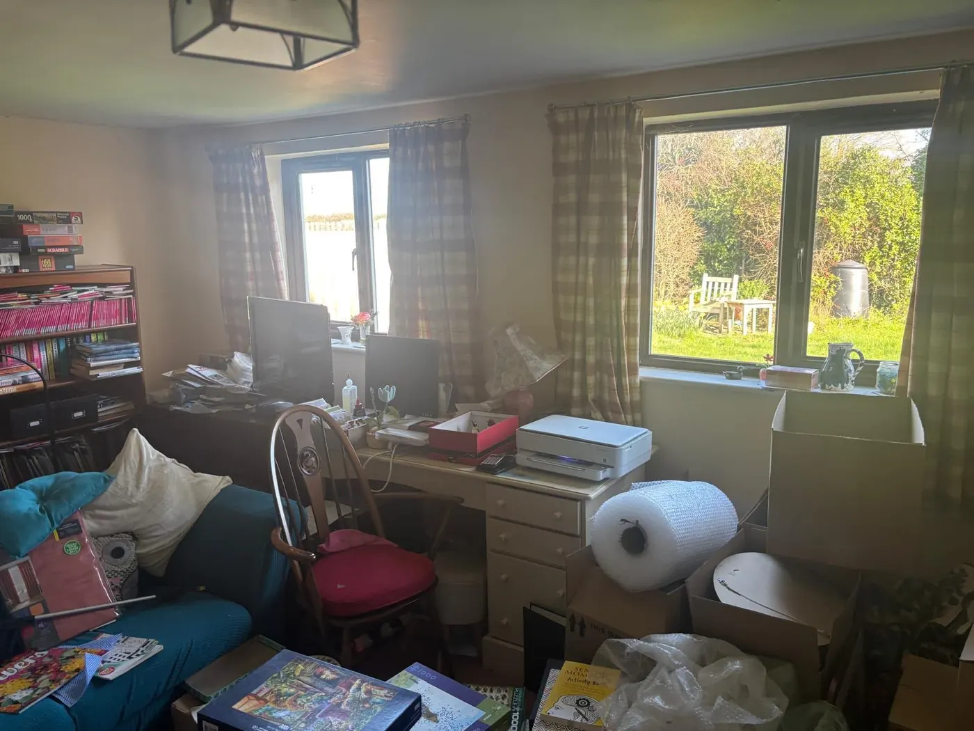 Partial clearance of a room containing a desk, sofa, boxes and old computer equipment